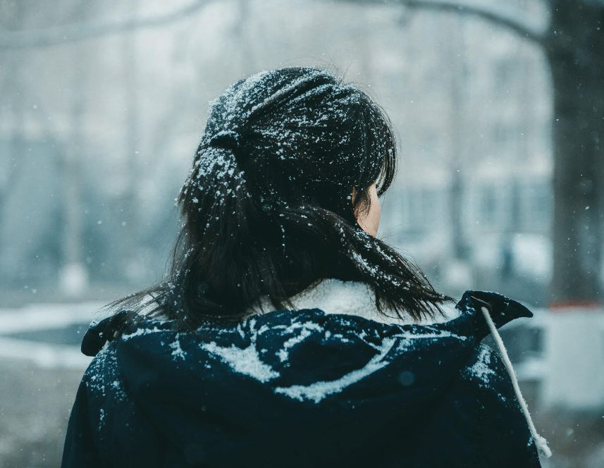 gloomy picture of woman looking away and snowing